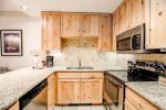 Updated, fully-equipped kitchen with granite countertops and stainless steel appliances